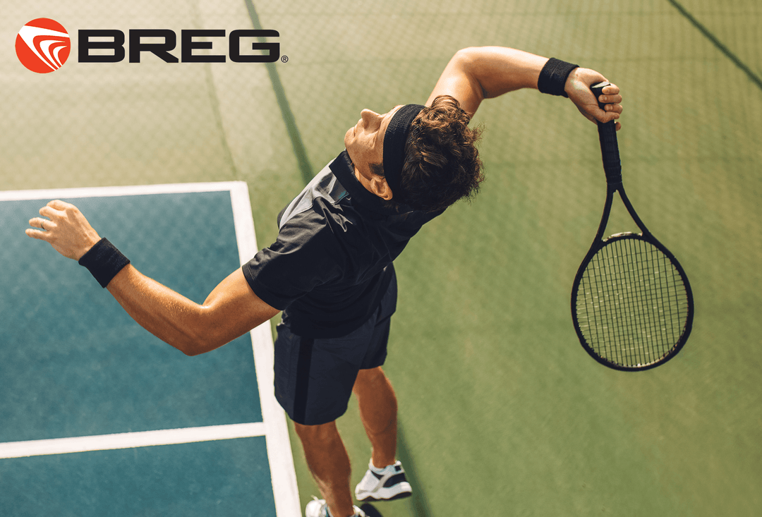 Tennis player serving on court with Breg logo, promoting cold therapy for sports injuries